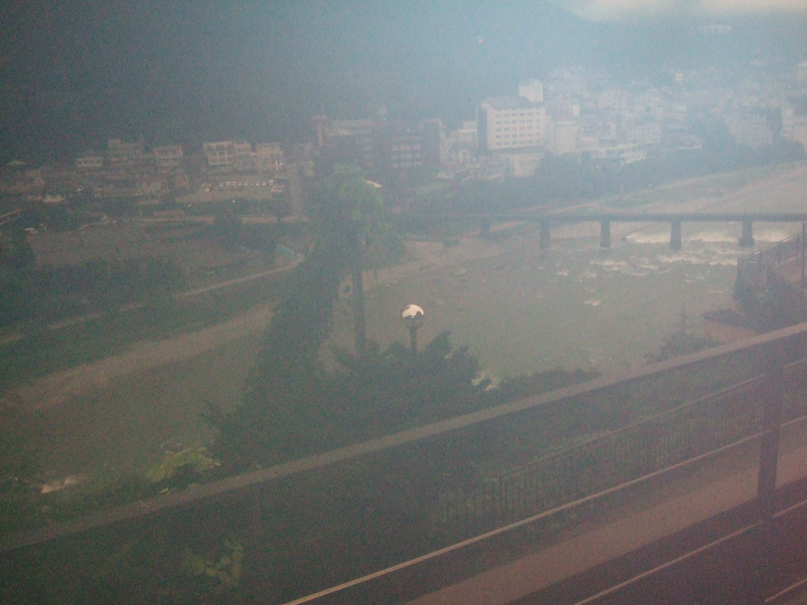 A hazy view of the Gero hot spring resort town from a high vantage point through a dense cloud of morning mist.