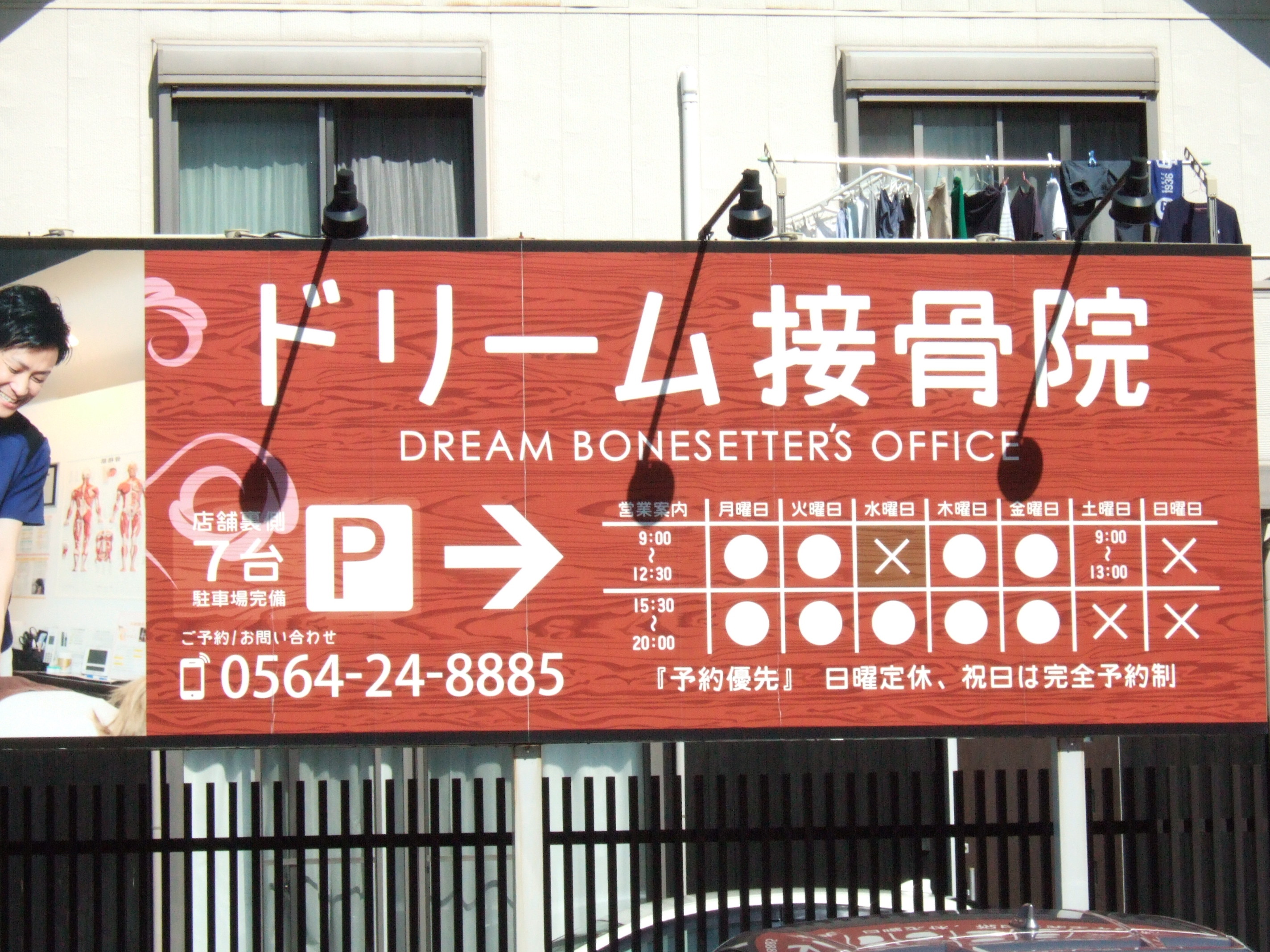 A sign in Japanese reading “ドリーム接骨院” and under that, “Dream Bonesetter’s Office,” followed by details of office hours and contact details. 接骨師 [sekkotsu-shi] is a qualification, 院 [in] is a clinic. The proper qualification name is 柔道整復師 [judo-seifuku-shi], with “judo” the same as the name of the sport. Like chiropractors, these aren’t medical clinics, but treatment by a “bonesetter” is covered by national insurance, with copays as usual. Service here is presumably less costly than treatment by a licensed osteopath.