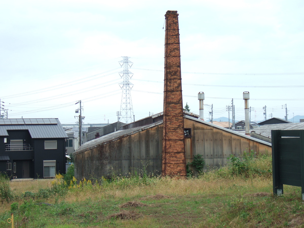 A closeup of the building with the chimney, showing its corrugated metal siding.