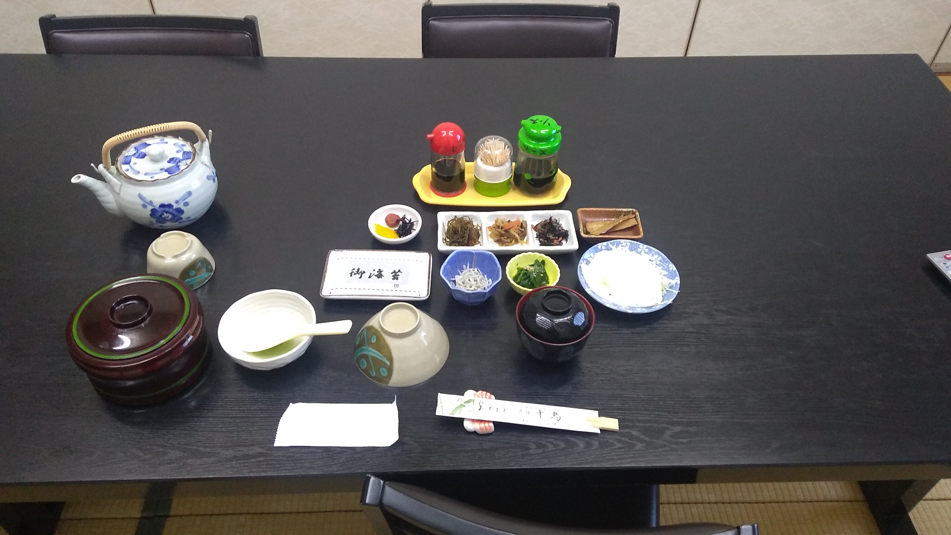 A traditional Japanese breakfast of rice, dried nori, condiments, a boiled egg, and miso soup.